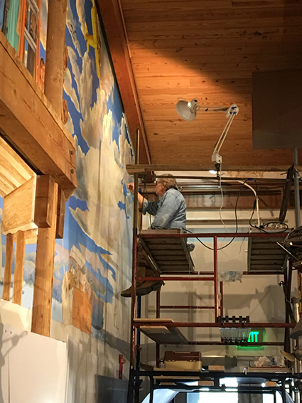 Tim Scheirer at work on a mural